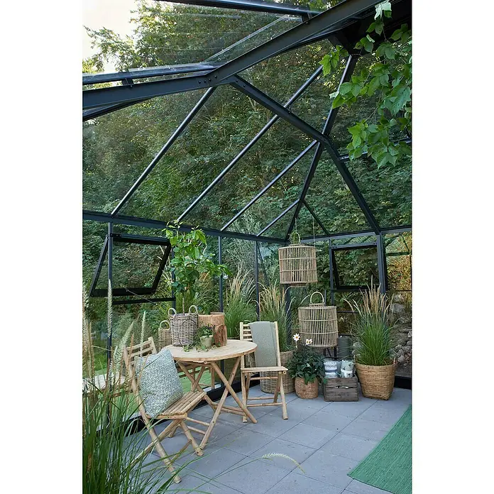 Juliana Gewächshaus Grand Oase - Außenmaß inkl. Dachüberstand (B x T): 439 x 583 cm, Material Seitenwand: Glas, 3 mm, Anthrazit/Schwarz - Ein gemütliches Gewächshaus mit Bambusmöbeln, Pflanzen und hängenden Laternen. Perfekt zum Entspannen und Genießen der Natur.