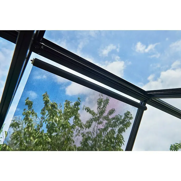 Halls Rollo - Schwarz, Passend für: Halls Gewächshäuser - Nahaufnahme einer schwarzen Jalousie vor einem Fenster mit Blick auf einen bewölkten Himmel und Bäume.