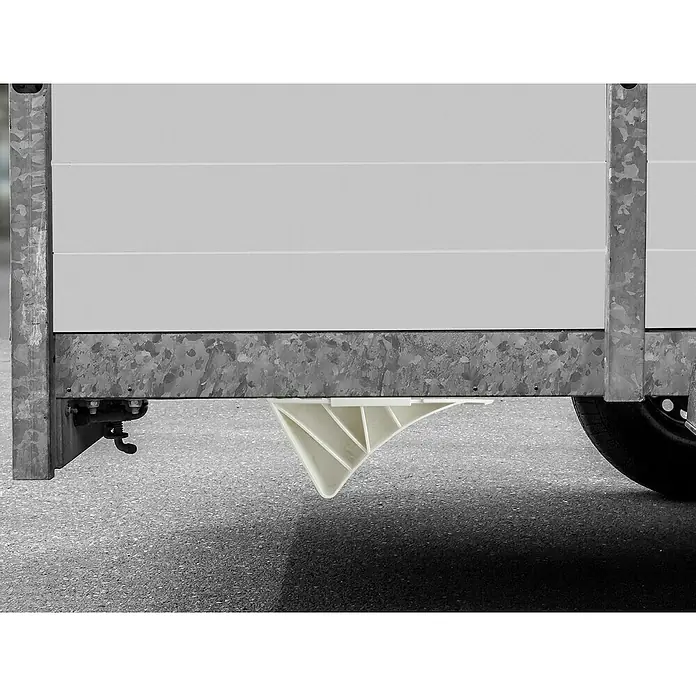 LAS Unterlegkeil - Max. zulässiges Gesamtgewicht: 1.600 kg - Detailansicht eines Anhängers mit hervorstechendem, weißem, dreieckigem Bauteil unterhalb der verzinkten Rahmenkonstruktion.