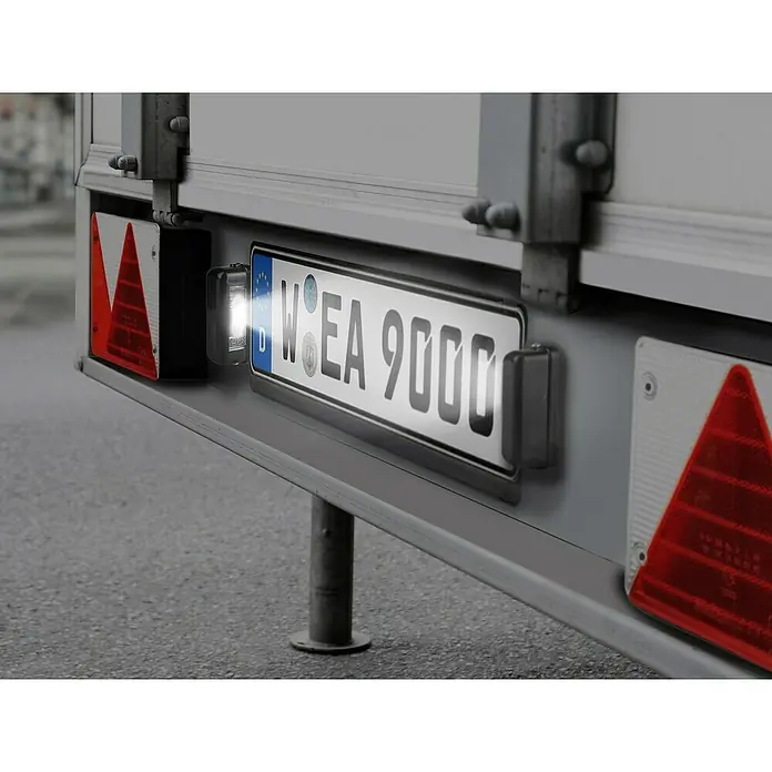 LAS Rückleuchte Multipoint III - links - Nahaufnahme der Kennzeichenleuchte an einem Anhänger, die das Nummernschild mit der Aufschrift W EA 9000 beleuchtet.