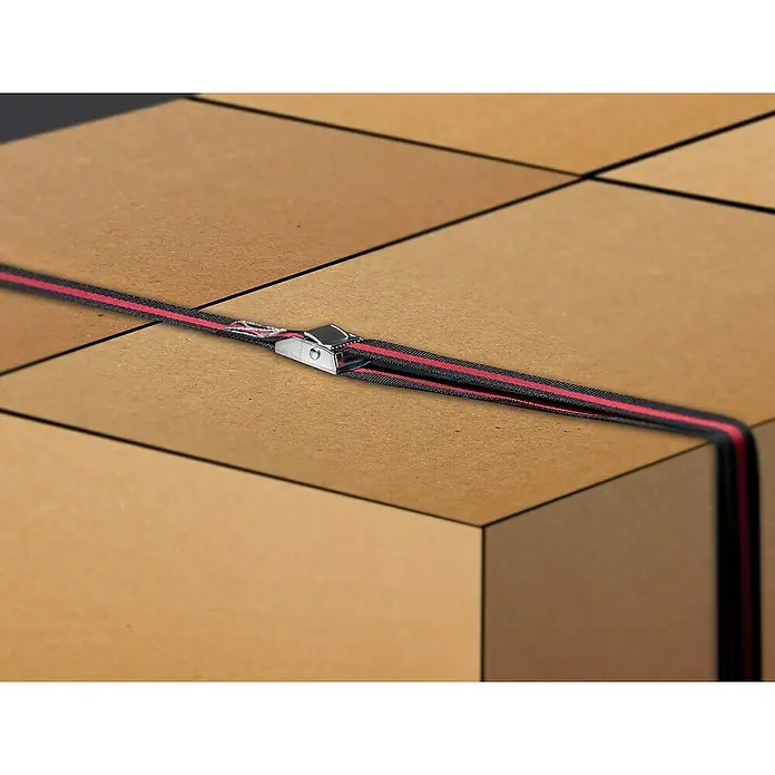 LAS Spanngurt5 m x 2,5 cm - Nahaufnahme von Kartons, die mit einem schwarzen Gurt mit rotem Streifen und Metallschnalle gesichert sind.