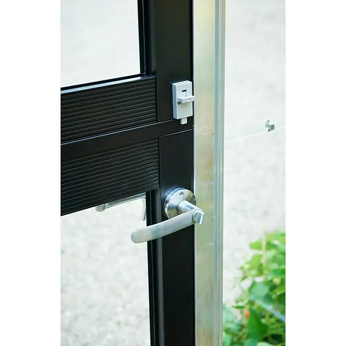 Juliana Gewächshaus Compact - Außenmaß inkl. Dachüberstand (B x T): 224 x 295 cm, Material Seitenwand: Glas, 3 mm, Silber/Schwarz - Detailaufnahme einer Tür mit silbernem Griff und grauem Riegel an einem schwarzen Rahmen, der einen modernen und funktionalen Stil zeigt.