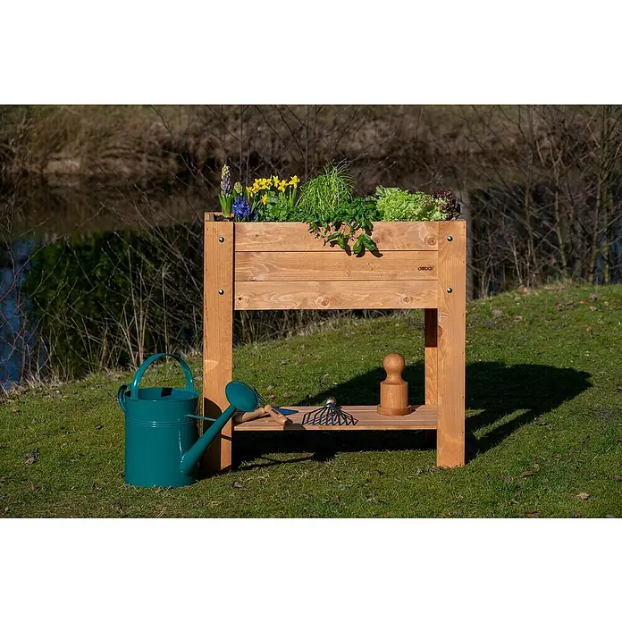 Dobar Hochbeet - L x B x H: 80,3 x 40 x 78,4 cm, Holz, Braun - Ein erhöhter Pflanzkasten aus Holz mit Pflanzen, einer Gießkanne und Gartengeräten vor einem Bach. Perfekt für den Gartenanbau.
