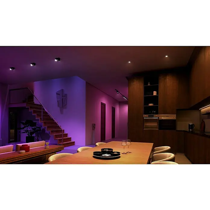 Philips Hue Smart-LED-Lampen Set White & Color Ambiance MR16 - GU5,3, Dimmbar, RGBW, 350 lm, 5,1 W, 1 Stk. - Stimmungsvolle Innenaufnahme mit moderner Beleuchtung, Treppe und Essbereich, die eine warme und einladende Atmosphäre schafft.