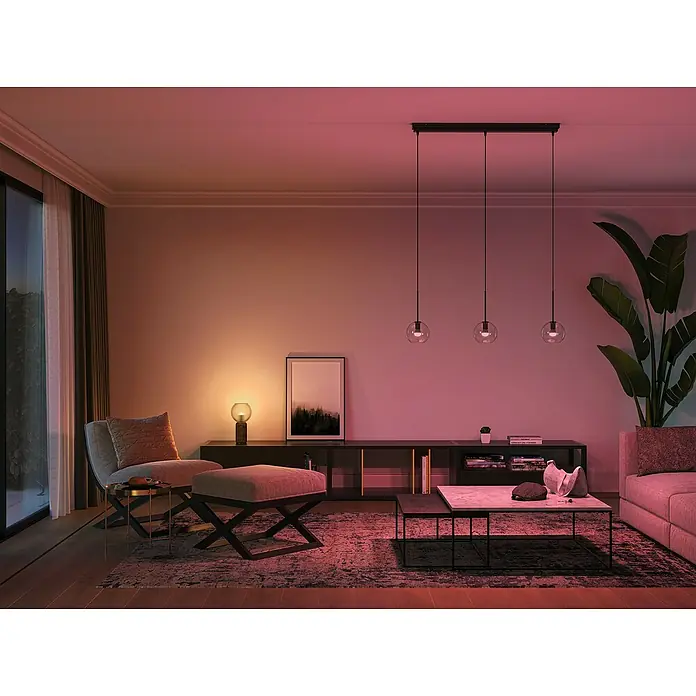 Philips Hue Smart-LED-Lampen Set White & Color Ambiance Tropfen - E14, Dimmbar, RGBW, 470 lm, 5,1 W, 2 Stk. - Innenaufnahme eines Wohnzimmers mit einer modernen Pendelleuchte über dem Couchtisch, die das Ambiente des Raumes hervorhebt.