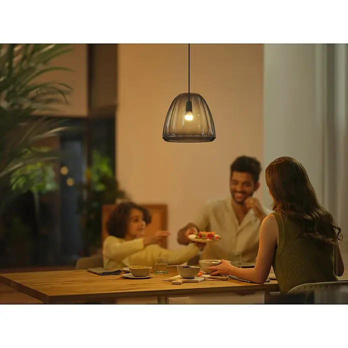 Philips Hue Smart-LED-Lampen Set White Ambiance Tropfen - E14, Dimmbar, Neutralweiß, 470 lm, 5,1 W, 2 Stk. - Die stilvolle Hängelampe beleuchtet eine Familie beim Abendessen und sorgt für eine gemütliche Atmosphäre im Raum.