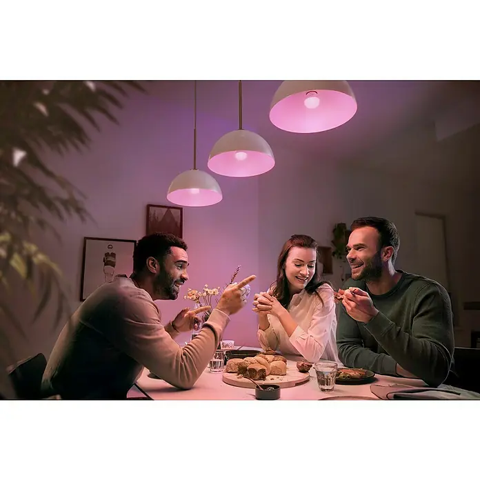 Philips Hue Smart-LED-Lampen Set White & Color Ambiance Tropfen - E14, Dimmbar, RGBW, 470 lm, 5,1 W, 1 Stk. - Eine gesellige Runde unter warmem, farbigem Licht, erzeugt durch die smarten Philips Hue Lampen, die eine gemütliche Atmosphäre schaffen.
