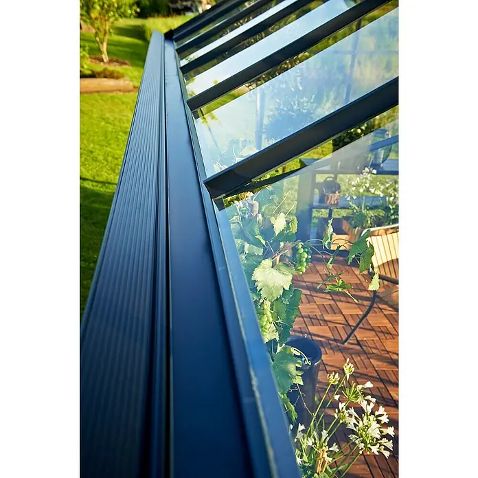 Juliana Gewächshaus Gärtner - Außenmaß inkl. Dachüberstand (B x T): 368 x 439 cm, Material Seitenwand: Kunststoff, 3 mm, Anthrazit/Schwarz, Stegdoppelplatten - Nahaufnahme eines Gewächshauses mit transparenten Glasscheiben und robusten Metallrahmen, die Pflanzen schützen.
