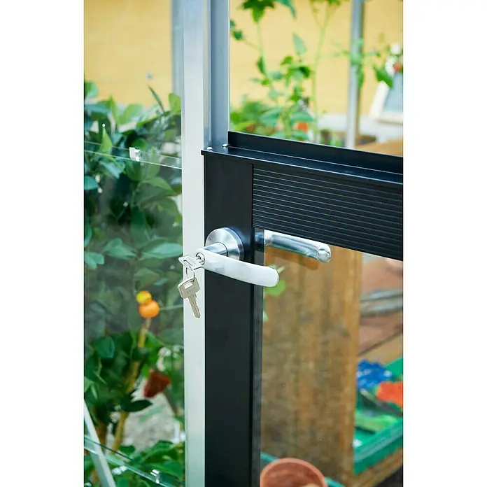 Juliana Gewächshaus Compact - Außenmaß inkl. Dachüberstand (B x T): 224 x 295 cm, Material Seitenwand: Kunststoff, 10 mm, Silber/Schwarz - Ein Gewächshaustürgriff aus Metall mit einem Schlüssel, der im Schloss steckt. Der Griff ist an einer schwarzen Tür befestigt und ein Aluminiumrahmen ist sichtbar.