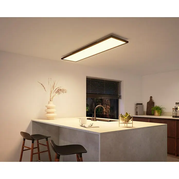 Philips Hue LED-Panel Aurelle39 W, L x B x H: 120 x 30 x 4,6 cm, Schwarz, Warmweiß - Das Bild zeigt eine Philips Hue Deckenleuchte in einem modernen Küchendesign, die warmes Licht spendet.