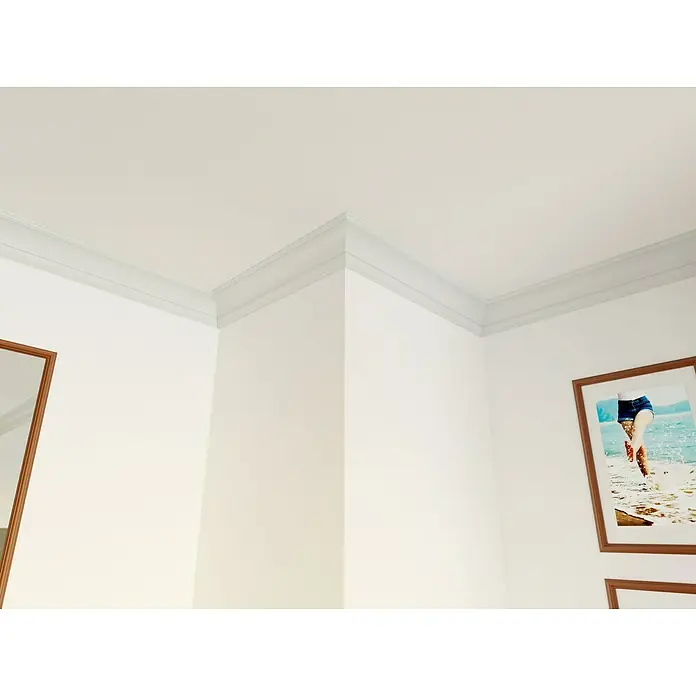 Nmc Decoflair Zierprofil Deckenleiste GO - 2 m x 80 mm x 80 mm, Extrudiertes Polystyrol (XPS) - Ein Innenraum mit einer weißen Zierleiste, die die Ecke von Wand und Decke betont und einen sauberen, architektonischen Übergang schafft.