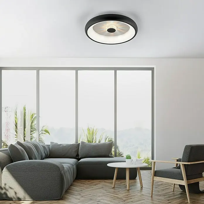 Just Light LED-Deckenleuchte rund VERTIGO - 33 W, Ø x H: 46,5 x 9,5 cm, Schwarz, Mehrfarbig - Deckenleuchte mit schwarzem Rand und zentralem Lichtelement in einem modern gestalteten Wohnzimmer mit großem Fenster.