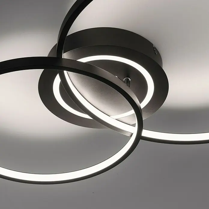 Just Light LED-Deckenleuchte ASMINA - 30 W, L x B x H: 69 x 55 x 9 cm, Schwarz, Warmweiß - Nahaufnahme einer modernen, schwarzen LED-Deckenleuchte mit verschlungenen Ringen und hellem, weißem Licht.