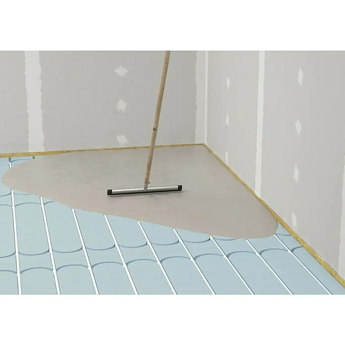 Fermacell Fußbodenheizelement Therm25 - 500 x 500 x 25 mm, Rundnuten - Das Bild zeigt das Verlegen einer Ausgleichsmasse auf einer Fußbodenheizung mit einer Rakel. Fokus liegt auf der selbstverlaufenden Bodenausgleichsmasse.