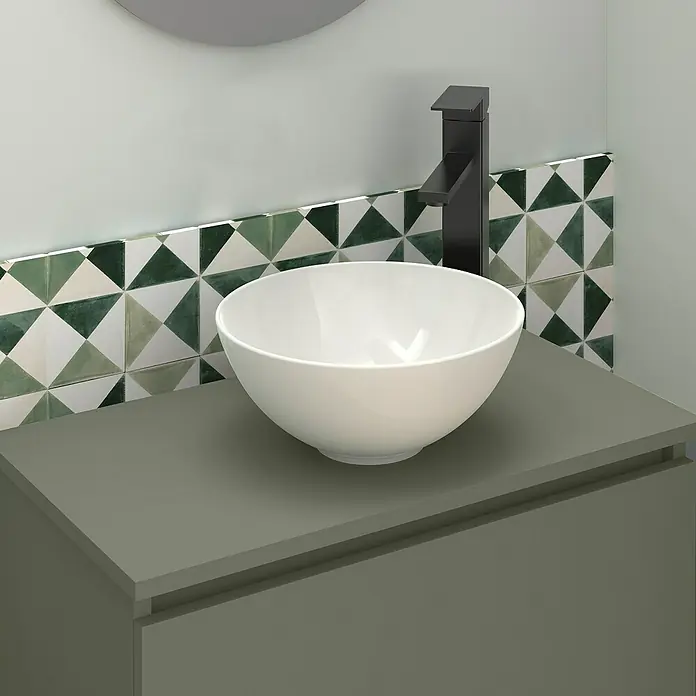 Artysan Conjunto de mueble de baño Nuca - Ancho: 60 cm, Verde Musgo, 3 pzs. - Primer plano de un baño moderno con un lavabo redondo sobre un tocador gris y un elegante grifo negro sobre azulejos estampados.