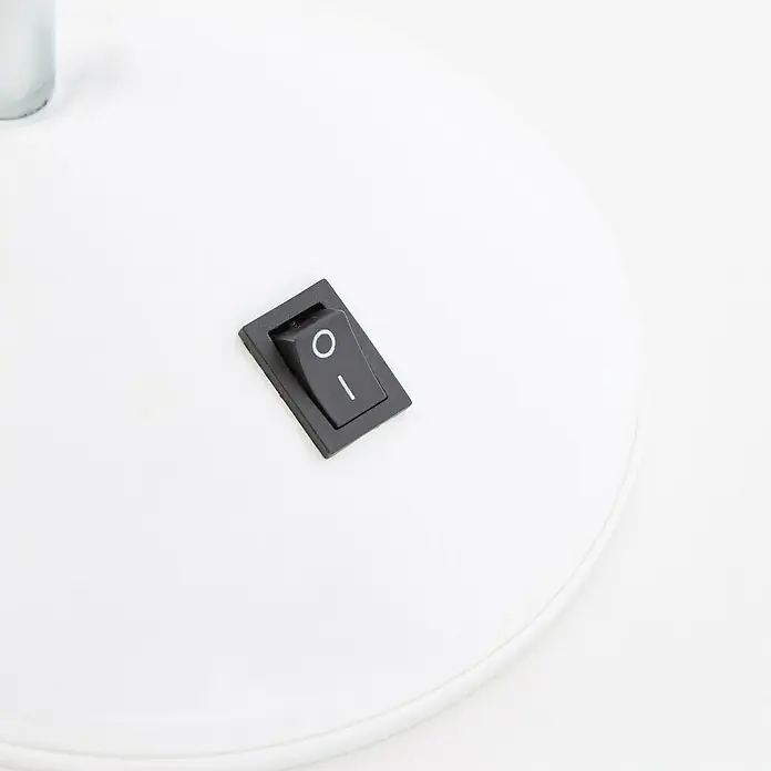 Brilliant LED-Tischleuchte Allison - L x B x H: 22 x 15,5 x 24,5 cm, Weiß - Detailaufnahme eines schwarzen Ein-/Ausschalters auf einer weißen Oberfläche, vermutlich Teil einer Lampe oder eines elektronischen Geräts.