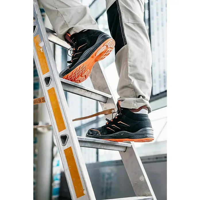 Botas de seguridad Gordon - 43, Clase de protección según EN ISO 20345: S1P, Negro/Naranja - Primer plano de botas de trabajo negras y naranjas en una escalera, ideales para la seguridad y estabilidad en entornos laborales exigentes.