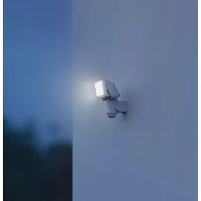 Steinel LED-Sensor-Strahler LS 150 S weiß - 14,7 W, L x B x H: 17 x 15,5 x 21,5 cm, Weiß, IP44 - Moderne Außenleuchte mit Bewegungsmelder an einer Wand, die bei Dunkelheit für Sicherheit sorgt und hell leuchtet.