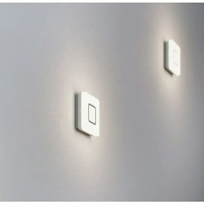 Steinel Sensor-Wand- & Deckenleuchte RS LED M1 S Edelstahl - 8,8 W, L x B x H: 20 x 20 x 5,3 cm, Weiß - Zwei moderne, quadratische LED-Wandleuchten in Weiß, die ein sanftes, indirektes Licht an die Wand werfen und ein minimalistisches Design aufweisen.
