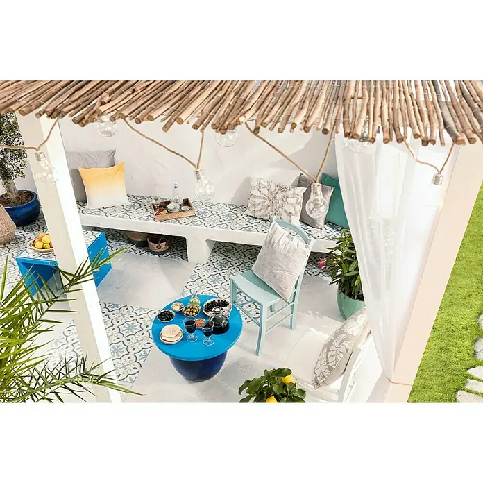 swingcolor Buntlack Acryl - Himmelblau, Seidenmatt, 375 ml, Wasserbasiert - Einladende Terrasse mit bequemen Sitzgelegenheiten, dekoriert mit blauen Akzenten und warmen Lichtern, die eine entspannte Atmosphäre schaffen.