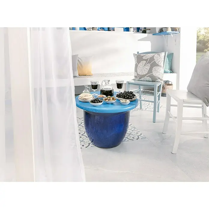 swingcolor Buntlack Acryl - Himmelblau, Seidenmatt, 375 ml, Wasserbasiert - Mediterrane Szene mit blauem Tisch, Geschirr und Stühlen in einem hellen, luftigen Raum mit weißen Vorhängen.