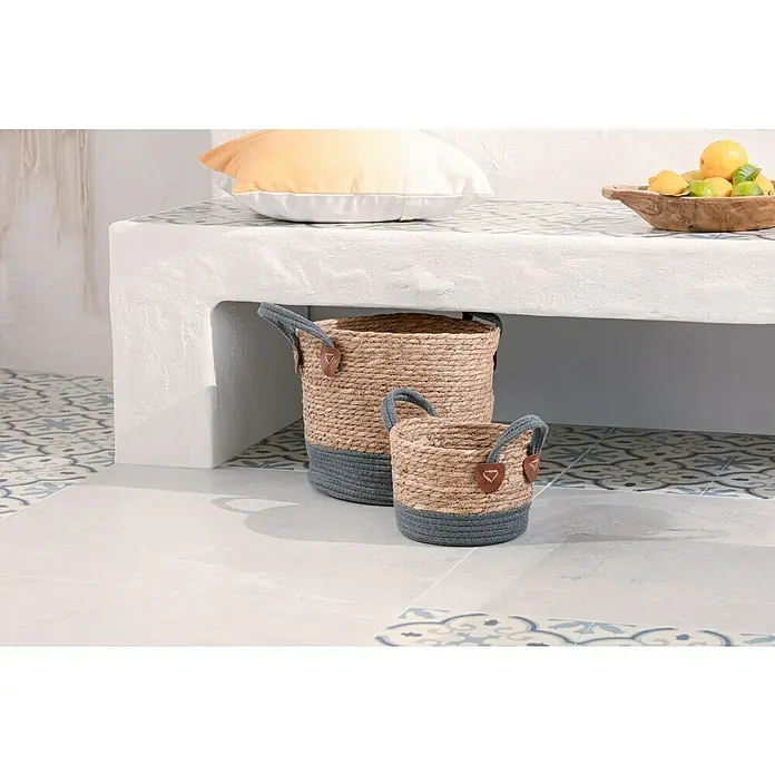SeegraskorbNatur/Grau, Ø x H: 29 cm x 35 mm - Zwei dekorative Körbe aus Seegras mit grauen Akzenten unter einer Bank, die eine stilvolle und praktische Aufbewahrungslösung bieten.