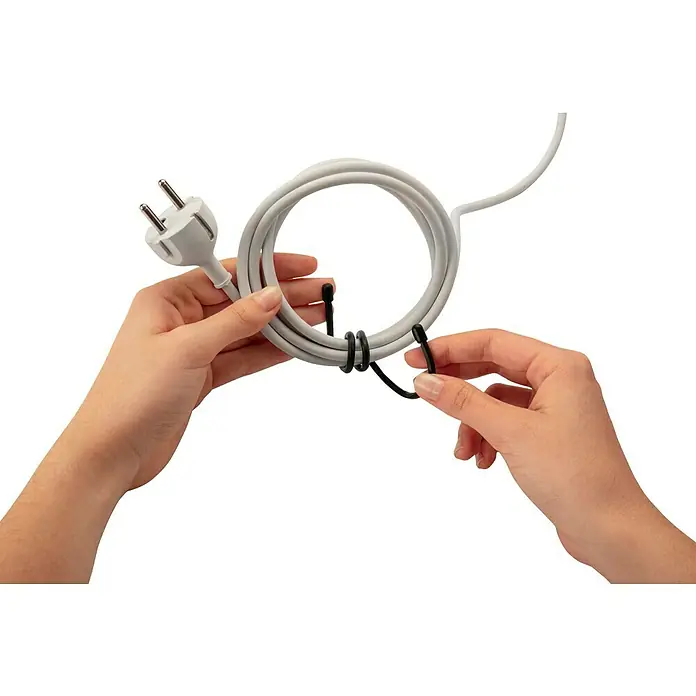 Inofix Bridas para cables Magic Tie - 2 ud., 25 cm, Negro - Primer plano de un cable sujeto con bridas y sostenido por manos. Perfecto para organizar la gestión de cables.