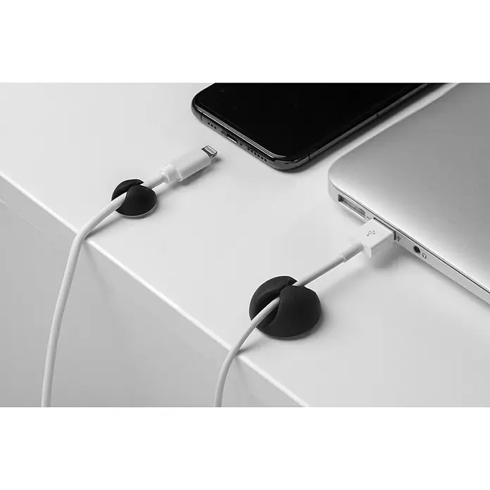 Inofix Fijación para cables adhesivo Mini - Blanco y Negro, 8 ud. - Cargadores y cables organizados con clips de cable en un escritorio blanco.