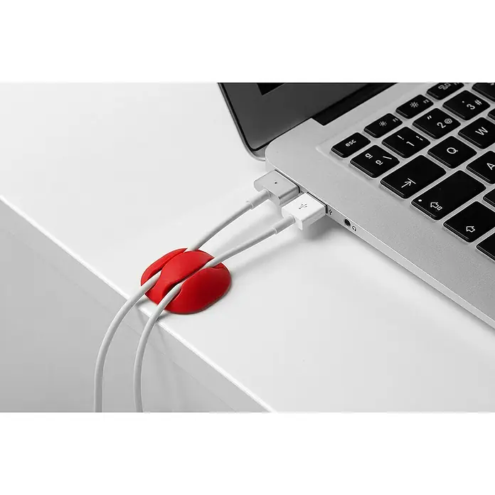 Inofix Fijación para cables adhesivo - Multicolor, 4 ud. - Un soporte de cable rojo mantiene dos cables blancos conectados a un portátil.
