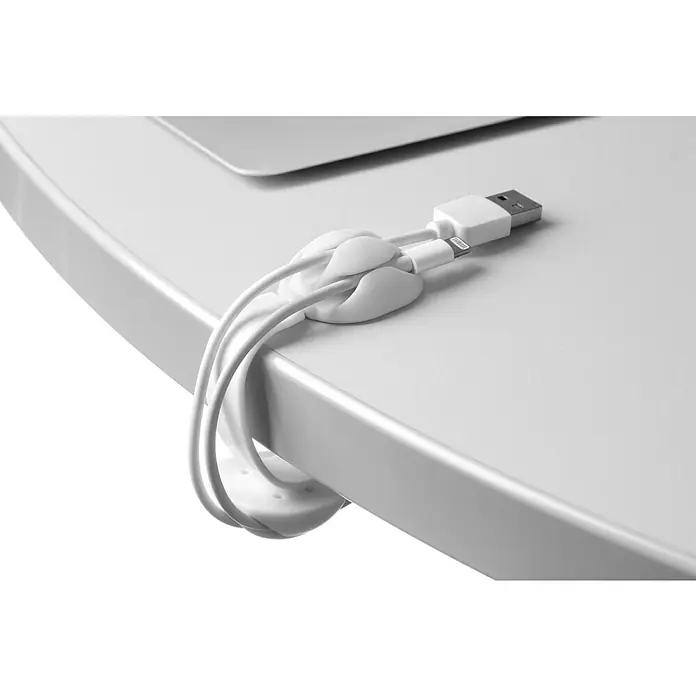 Inofix Fijación para cables de clip adhesivo - Blanco, 1 ud. - Primer plano de un clip de cable blanco con tres cables blancos sobre una mesa blanca.