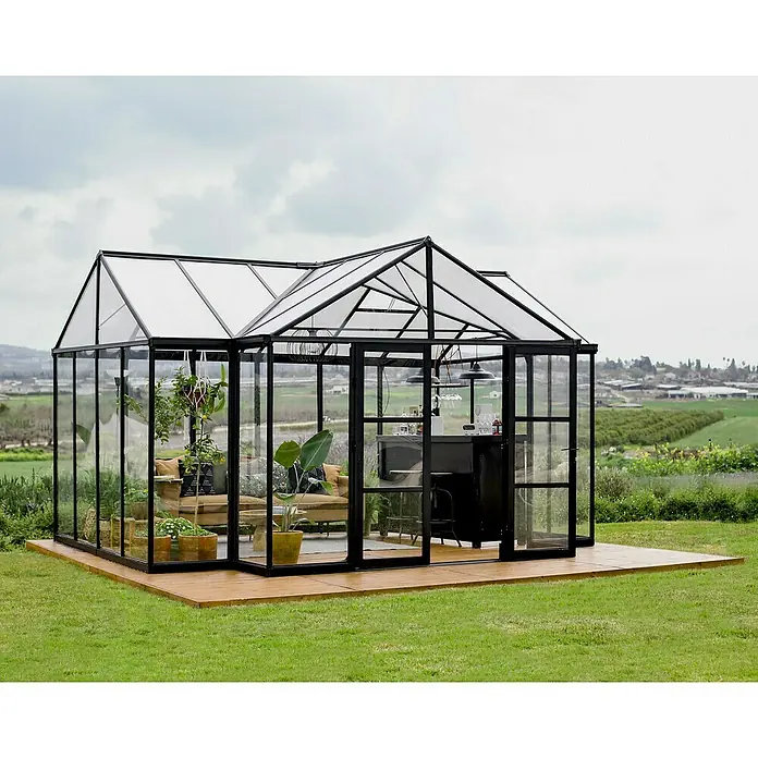 Palram – Canopia Invernadero Triomph Orangery - Medidas ext. (An x Pr): 454 x 380 cm, Material de la pared lateral: Plástico, 2 mm, Antracita - Un espacioso invernadero con estructura negra transformado en un salón elegante con bar y zona de estar, ideal para relajarse en el jardín.
