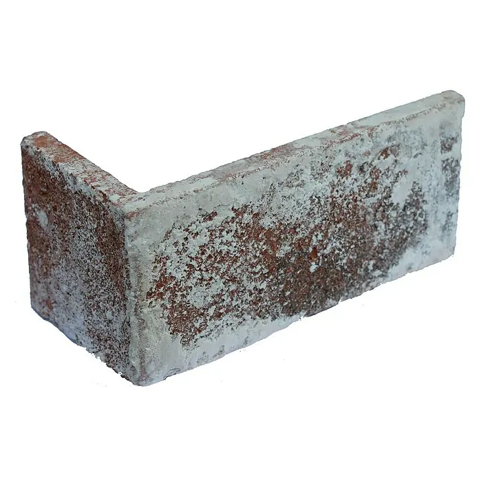 Celina Klinker Verblendstein-Ecke Vintage Brooklyn - 11,5 cm x 5,2 cm x 7 mm, Rot/Weiß, Steinoptik - Nahaufnahme eines Eckstücks eines roten Ziegels mit weißem Ausblühungseffekt, der die Textur und Farbe des Baumaterials hervorhebt.