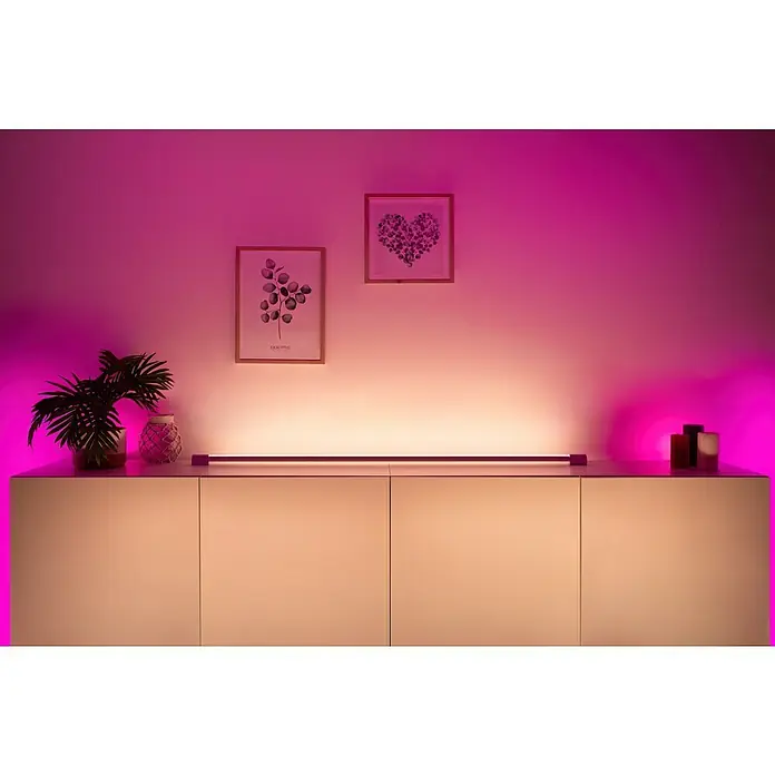 Philips Hue LED-Lichtleiste Gradient Light Tube - Weiß, Länge: 137,7 cm - Einrichtung mit einem Philips Hue Lightstrip, der indirektes Licht spendet. Dekorative Elemente und zwei Bilder an der Wand ergänzen das Ambiente.