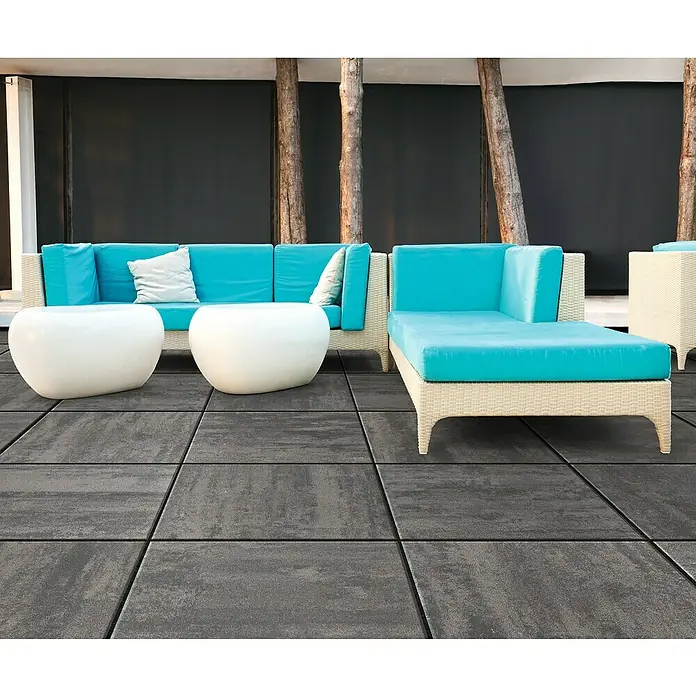 Terrassenplatte Saturn - 50 x 50 x 4 cm, Grau, Beton - Stilvolle Terrassengestaltung mit grauen Fliesen, ergänzt durch eine moderne Sitzgruppe mit türkisfarbenen Polstern und weißen Tischen.