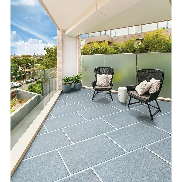 Terrassenplatte Pietra Serena - 40 x 60 x 4 cm, Granitgrau, Beton - Einladender Balkon mit grauen Bodenfliesen, stilvollen Sesseln und dekorativen Kissen für entspannte Stunden im Freien.