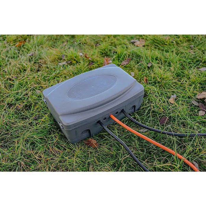 Brennenstuhl Kabelbox - L x B x H: 34 x 23 x 12,5 cm, IP54 - Die graue Anschlussdose auf dem Gras ist über Kabel mit der Stromversorgung verbunden. Stromkasten für den Aussenbereich auf Rasen.