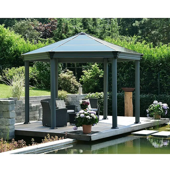 Palram – Canopia Standard-Pavillon Roma - B x T: 359 x 414,5 cm, Farbe Gestell: Anthrazit, Aluminium - Elegantes Gartenpavillon mit Überdachung und Sitzgelegenheiten auf einer Holzplattform am Wasser, umgeben von üppigem Grün.