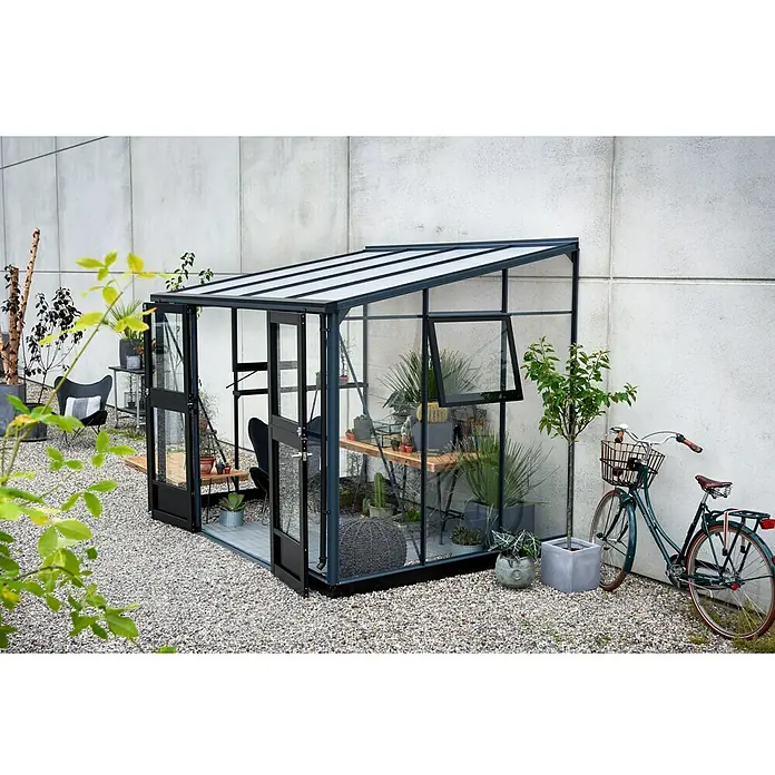 Juliana Gewächshaus Veranda - Außenmaß inkl. Dachüberstand (B x T): 221 x 296 cm, Material Seitenwand: Glas, 3 mm, Anthrazit - Geräumiges Gewächshaus mit Pflanzen und einem Fahrrad davor, das einen idyllischen Gartenraum schafft.