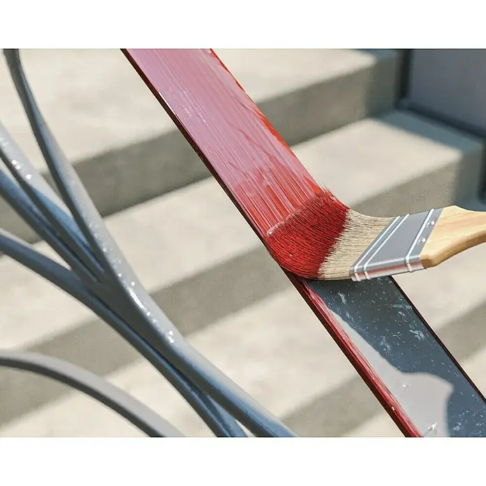 swingcolor Buntlack Kunstharz für Außen - Feuerrot, Hochglänzend, 125 ml, Lösemittelbasiert - Nahaufnahme eines Pinsels, der rote Farbe auf ein Metallgeländer aufträgt, wobei der Fokus auf der Verwandlung des Geländers liegt.