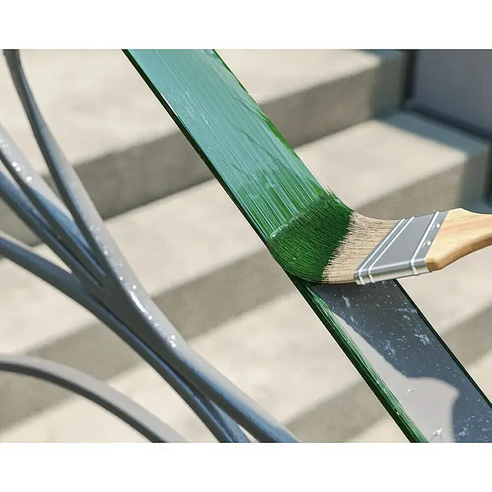 swingcolor Buntlack Kunstharz für Außen - Laubgrün, Hochglänzend, 125 ml, Lösemittelbasiert - Ein Pinsel trägt grüne Farbe auf ein Metallgeländer auf, wobei ein Teil des Geländers noch grau ist. Farbige Außendekoration mit Pinsel.