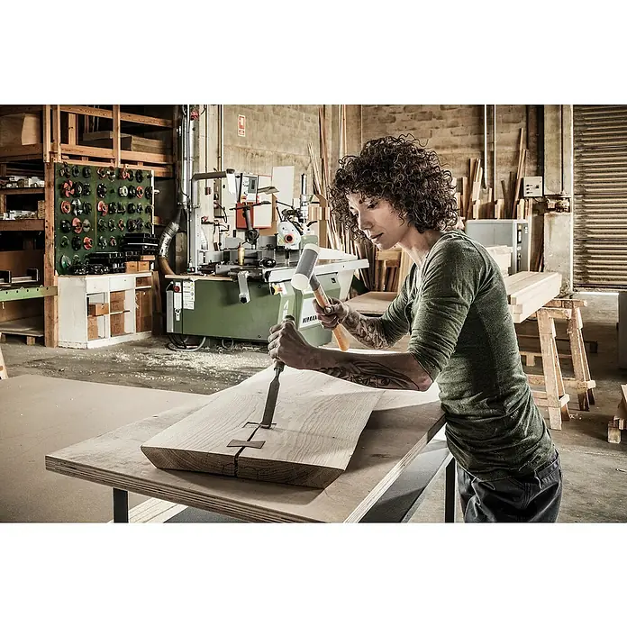 Halder Supercraft Schonhammer - Durchmesser Kopf: 40 mm, Holz - Ein Schreiner bearbeitet ein Holzstück mit einem Stecheisen und einem Hammer in seiner Werkstatt.