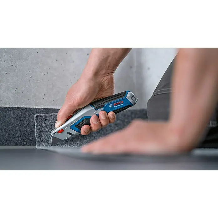 Bosch Professional Cuttermesser - 4 -tlg., Trapezklinge - Detailaufnahme eines Bosch Professional Universal-Cuttermessers im Einsatz, ideal zum Zuschneiden von Materialien, für Handwerker und Heimwerker.