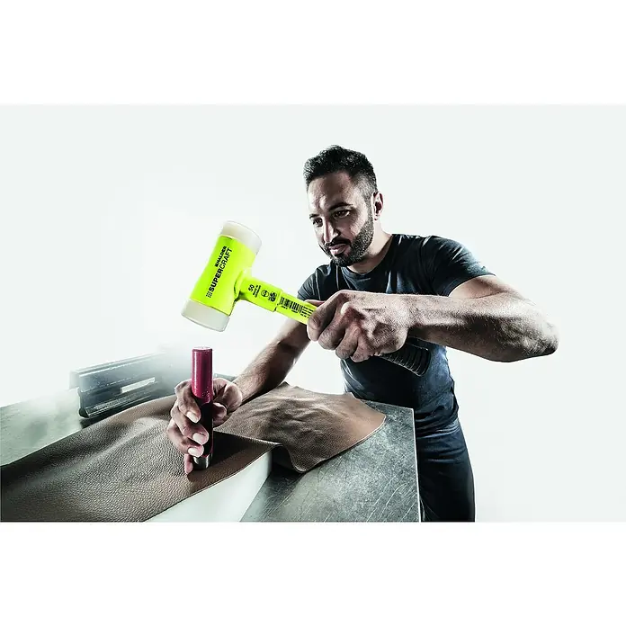 Halder Supercraft Schonhammer - Durchmesser Kopf: 50 mm, Kunststoff - Ein Mann benutzt einen Schalder Supercraft Hammer, um Leder zu bearbeiten. Der Hammer ist gelb mit einem weißen Kopf, ideal für präzise Handwerksarbeiten.