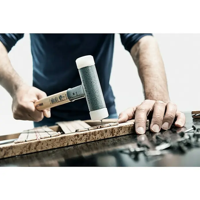 Halder Supercraft Schonhammer - Durchmesser Kopf: 32 mm, Holz - Ein Handwerker befestigt Polstergurte mit einem Schonhammer an einem Holzrahmen. Präzises Werkzeug für Polsterarbeiten.