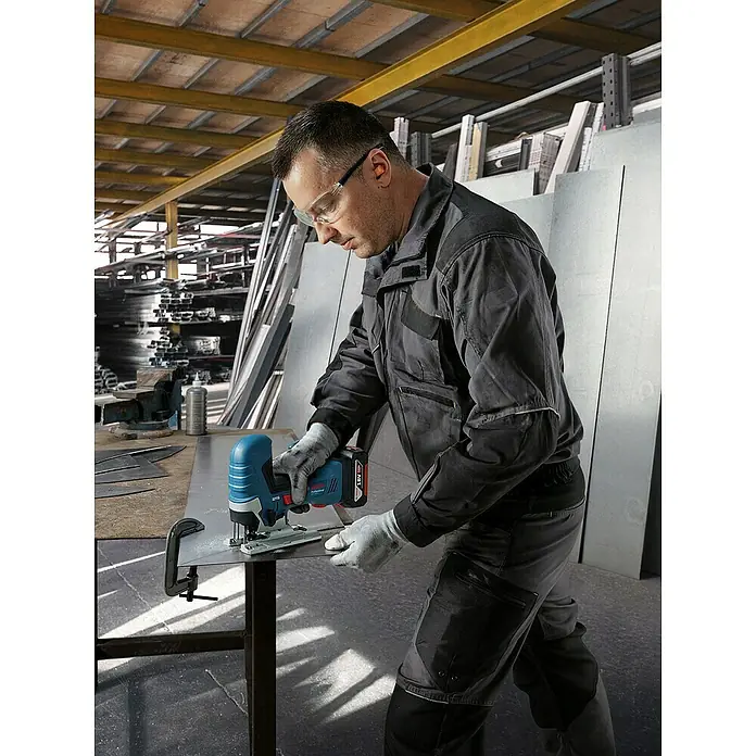 Bosch Professional AMPShare 18V Akku-Stichsäge GST 18V-125 S - 18 V, Ohne Akku, Leerlaufhubzahl: 500 /min - 3.500 /min - Ein Handwerker benutzt eine Bosch Akku-Stichsäge, um Metall zu schneiden. Die Stichsäge ist blau und hat einen schwarzen Griff.