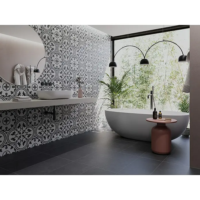 Feinsteinzeugfliese Classico Nero - 44 x 66 cm, Schwarz, Matt - Badezimmer mit freistehender Badewanne unter Bogenleuchten, Waschbecken auf Konsole vor gemusterter Wand und dunklem Fliesenboden.