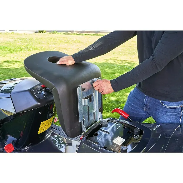 AL-KO Easy Rasentraktor 15-93.2 HDS-A - 452 cm³, Schnittbreite: 93 cm - Nahaufnahme eines Mannes, der den Sitz eines Rasenmähers einstellt, mit Fokus auf den Sitz und die Bedienelemente des Mähers.