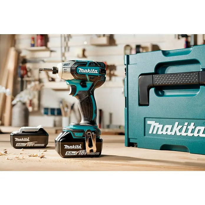 Makita LXT 18V Akku-Impulsschrauber DTS141RTJ - 18 V, 2 Akkus, 5 Ah, 40 Nm - Nahaufnahme eines Makita Akku-Schlagschraubers mit Zubehör, ideal für Profis und Heimwerker. Der Schrauber wird in einem robusten Koffer geliefert.