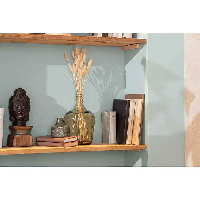 Buddhakopf - 17 x 31 cm, Dunkelgrau - Nahaufnahme eines Bücherregals mit einer Buddha-Statue, einer Vase mit Blumen und einigen Büchern, die eine ruhige Atmosphäre ausstrahlen.