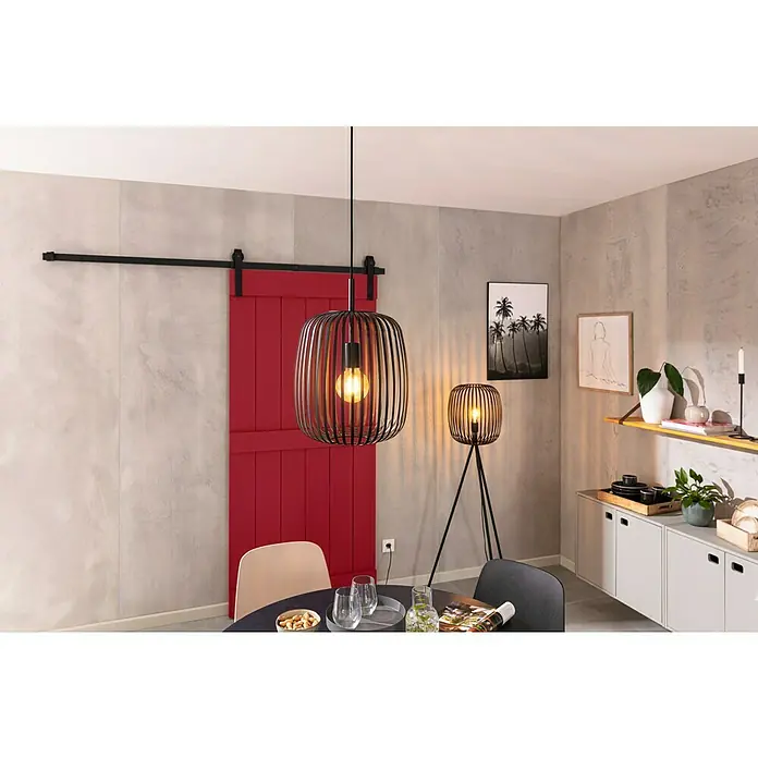 Kerzenhalter Fio - 1 Stk., Schwarz, 32 cm, Metall - Innenansicht eines Raumes mit einer auffälligen, modernen Pendelleuchte und einer passenden Stehlampe, die ein warmes Licht verbreiten.